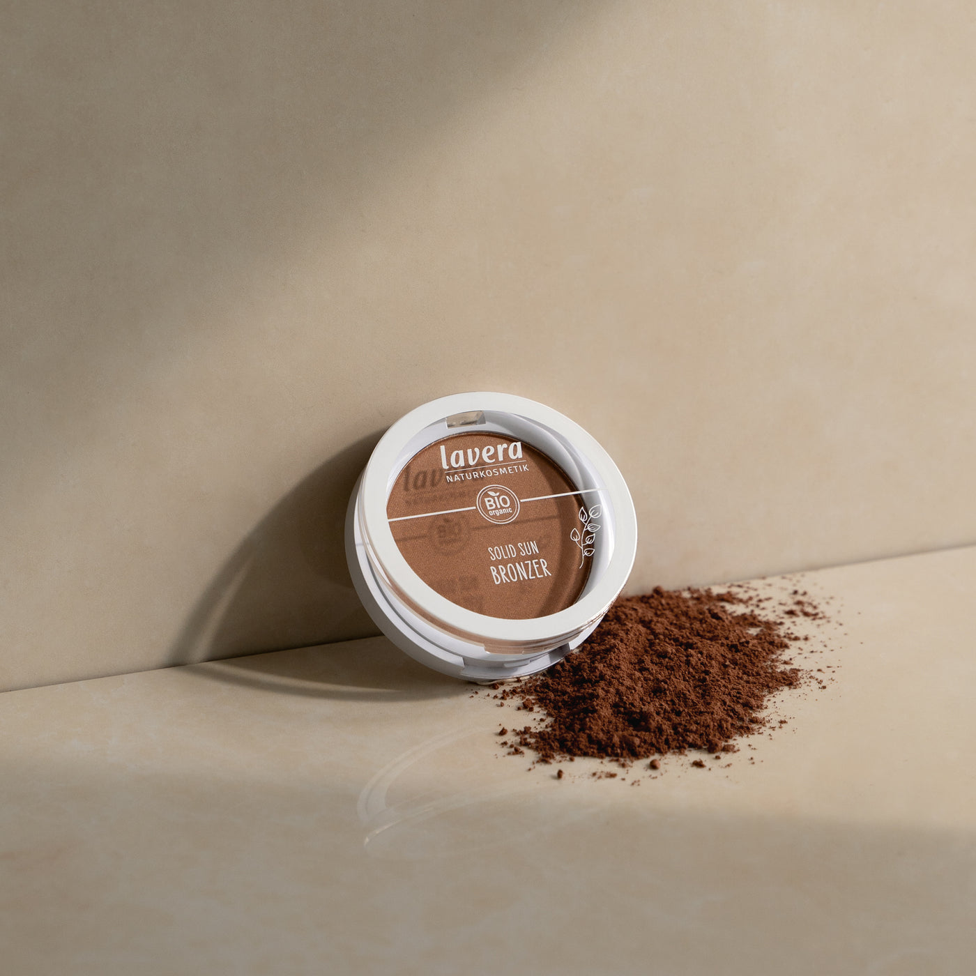 lavera Solid Bronzer oparty o beżową ścianę
