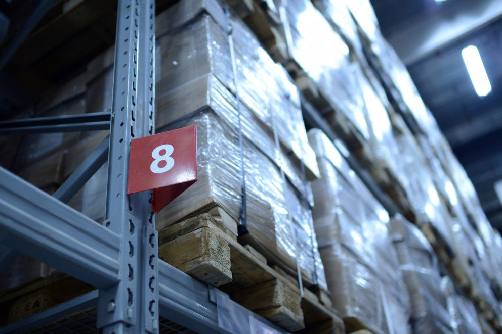 Paletten im Lagerregal mit rotem Feld „8“, Logistik und Versand
