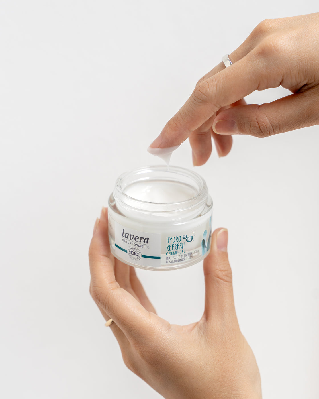 Dłoń trzyma słoiczek z kremem