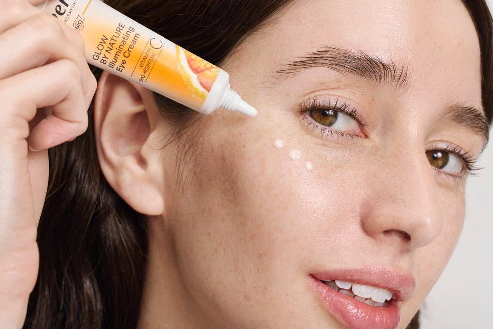 Frau trägt Glow by Nature Augencreme unter dem Auge auf, Nahaufnahme