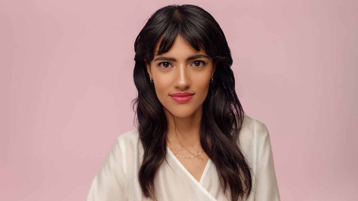 Młoda kobieta o ciemnobrązowych włosach, brązowych oczach i eleganckim makijażu