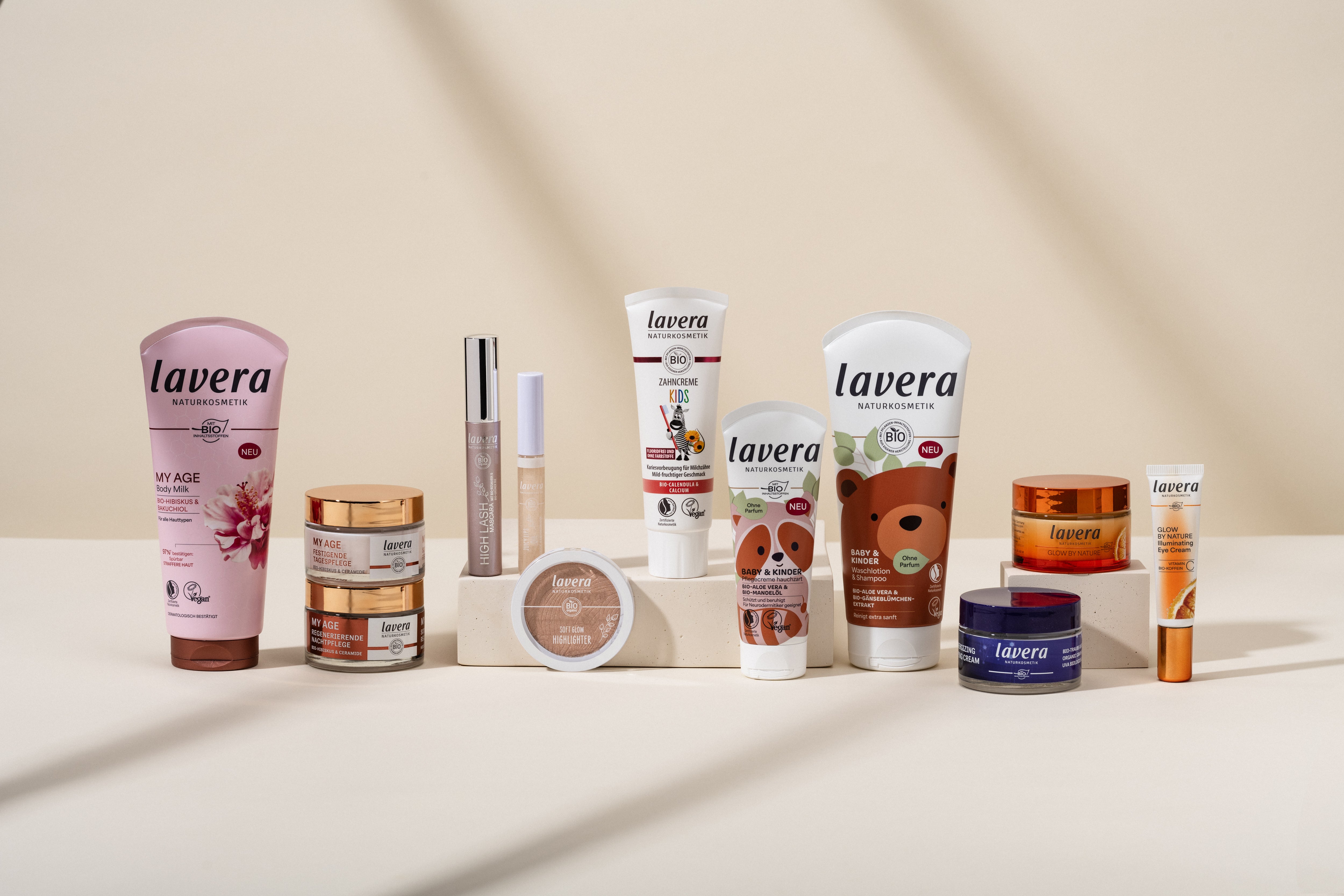 Range an unterschiedlichen lavera Produkten vor beschem Hintergrund mit Schatteneffekten