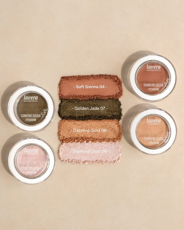 Cztery próbki cieni do powiek lavera w kolorach Soft Sienna, Golden Jade, Dazzling Gold i Diamond Dust obok opakowań produktów.