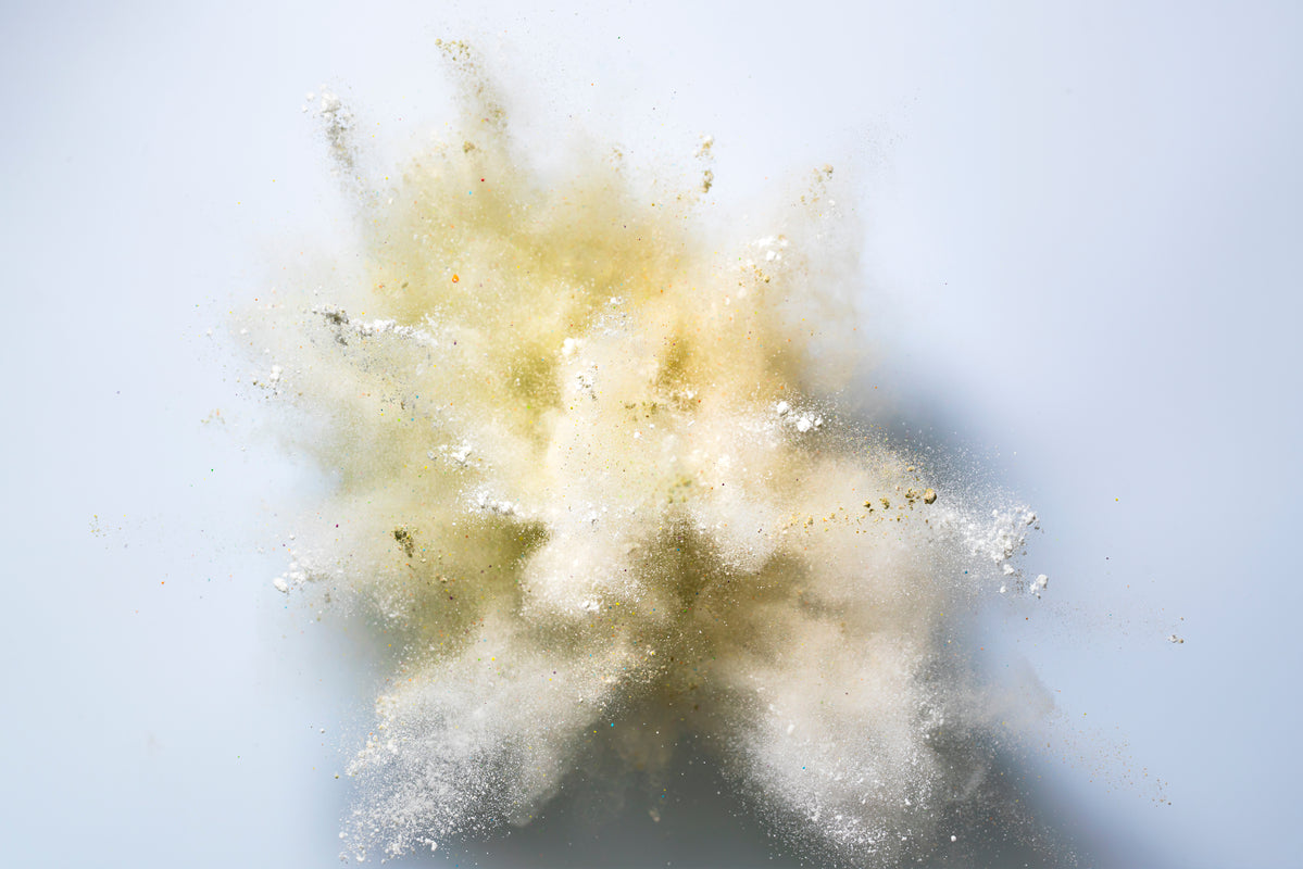 Argininpuder explodiert vor einem weißen Hintergrund