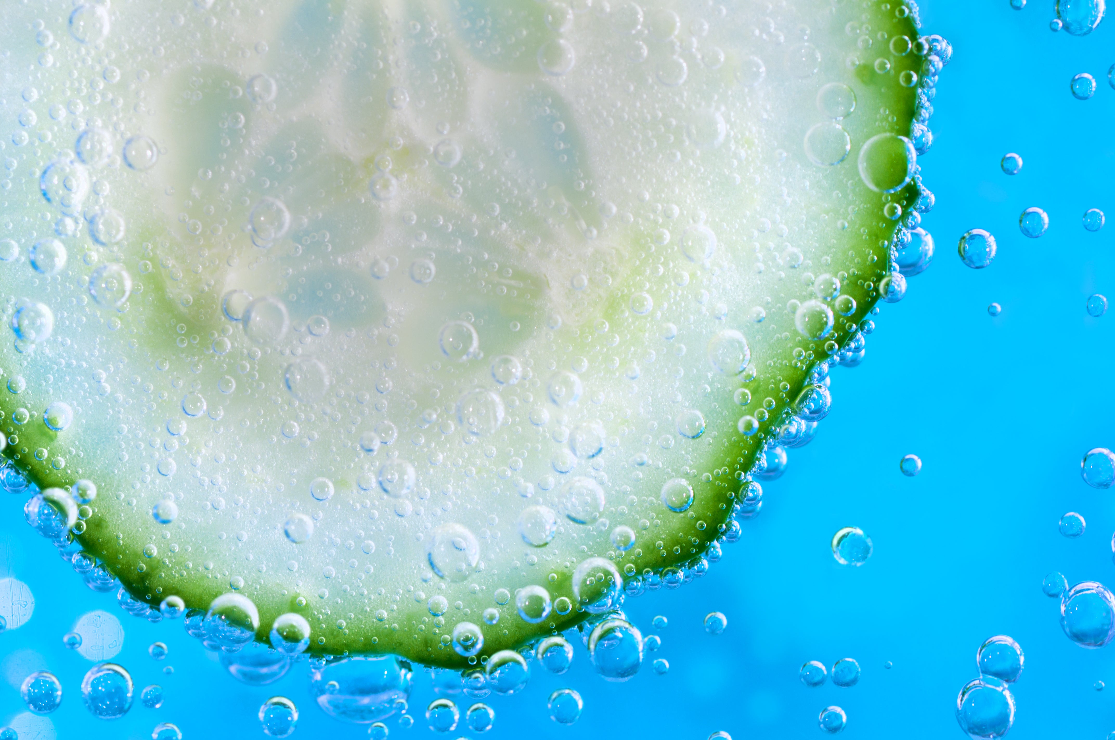 Gurkenscheibe in Wasser mit Luftblasen