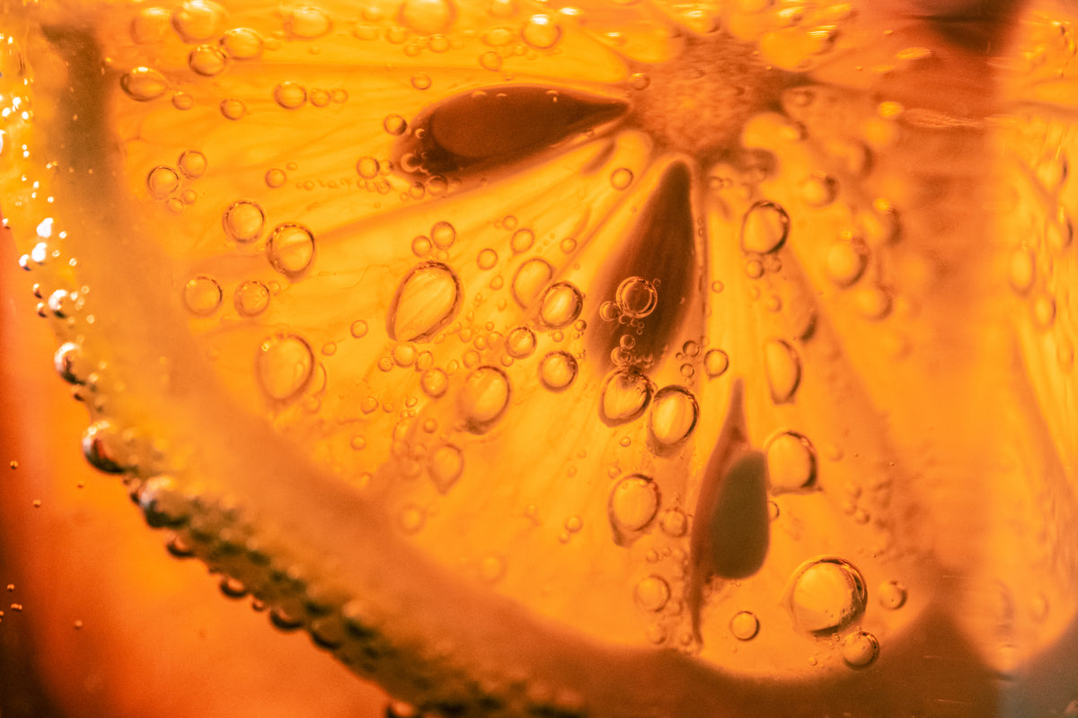 Nahaufnahme einer Orange in orangener Flüssigkeit