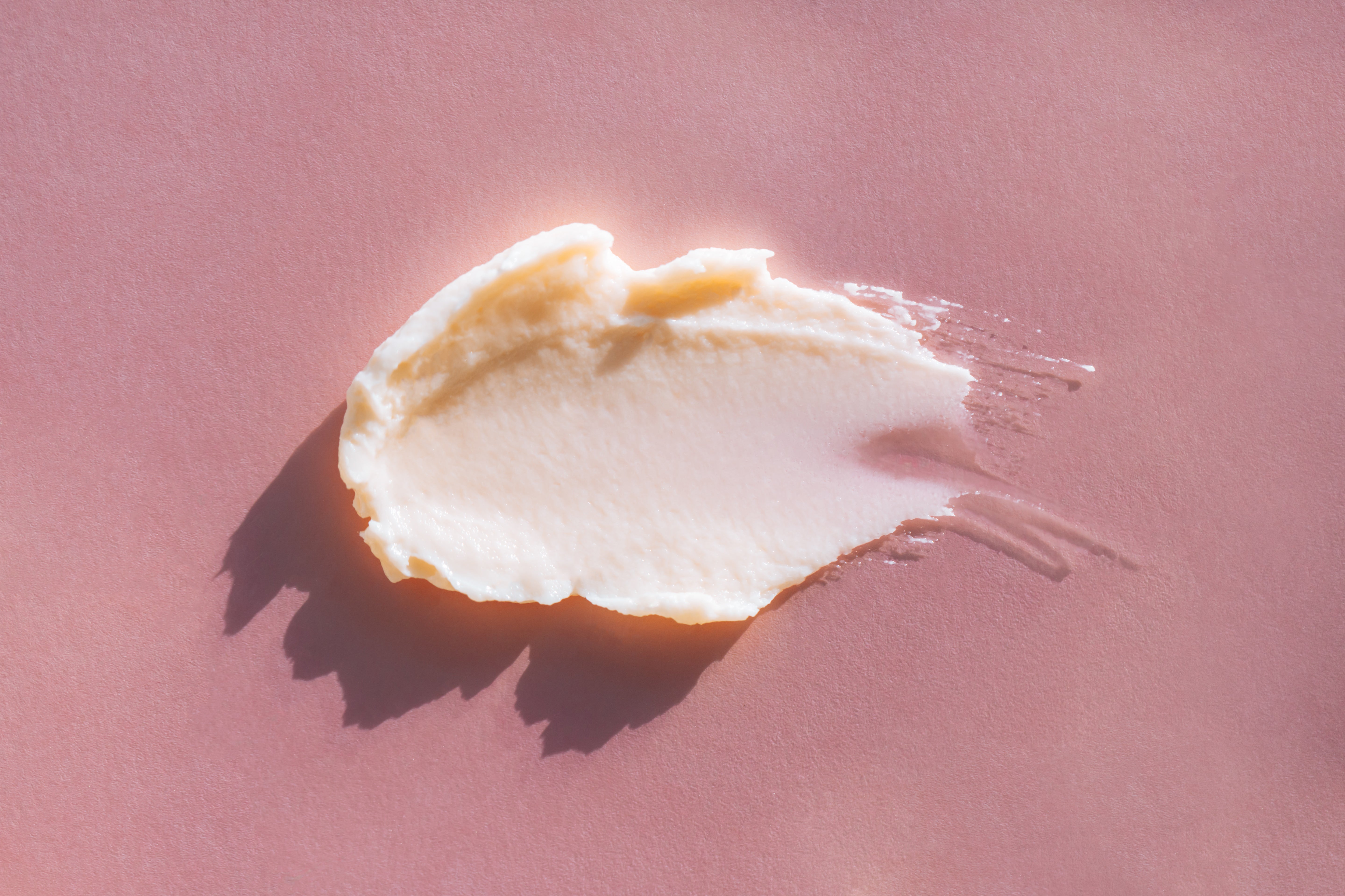 cremige Textur auf pinken Hintergrund