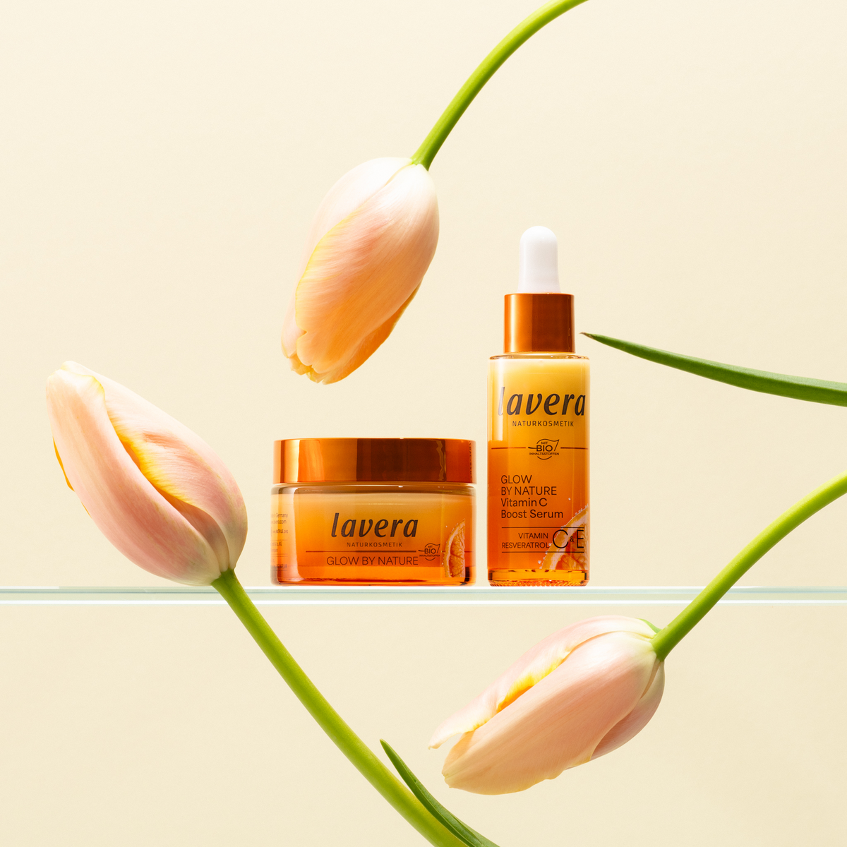 Glow by Nature Creme und Serum zwischen Tulpen
