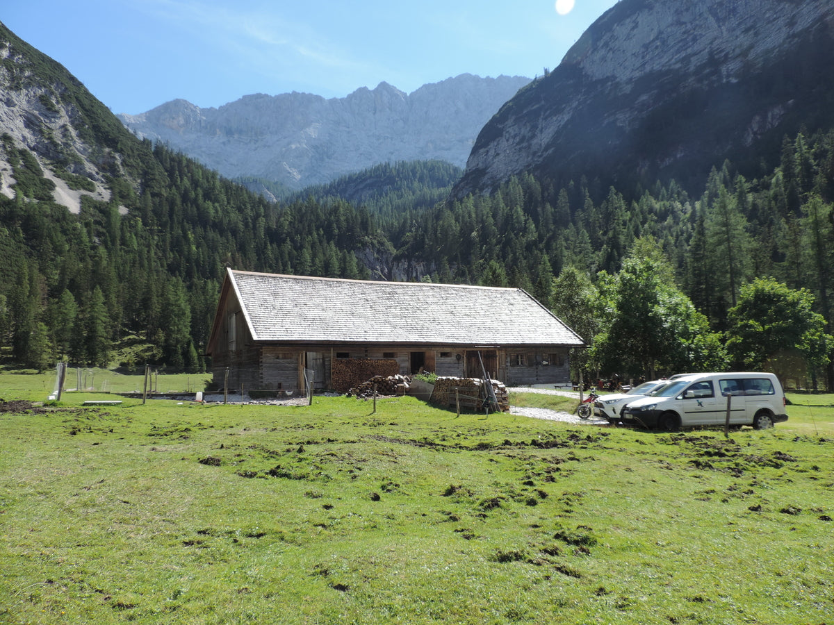 Alpejska chata z drewna w górach przy słońcu