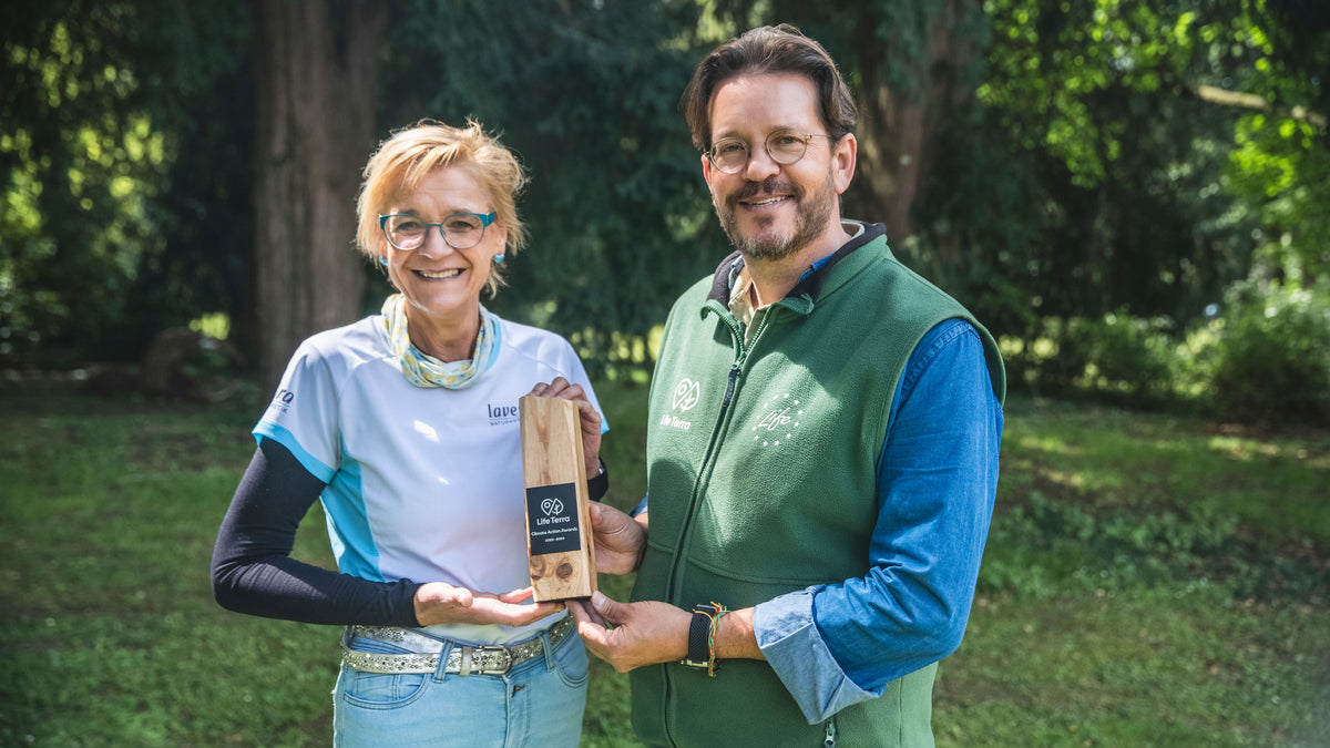 Mężczyzna z LifeTerra i Sabine Kästner obok siebie i trzymają drewnianą nagrodę