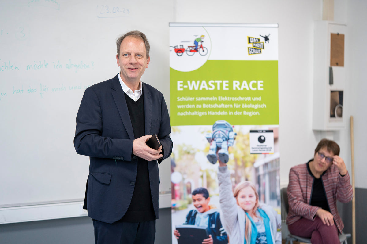 Prof. Fleisch steht in einem KLassenraum vor einem E-Waste-Race Aufsteller