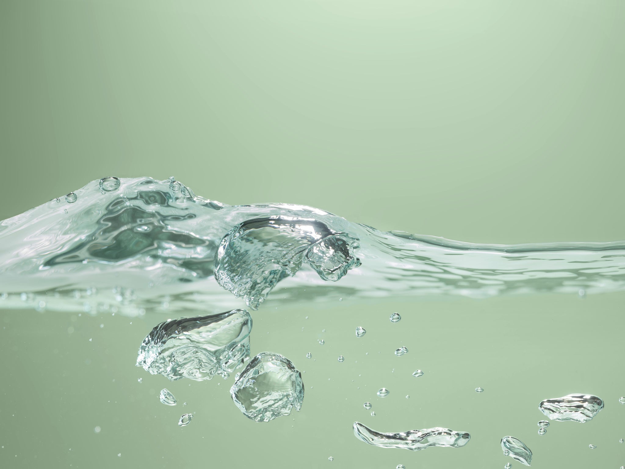 Zbliżenie rozpryskującej się fali wodnej na zielonym tle