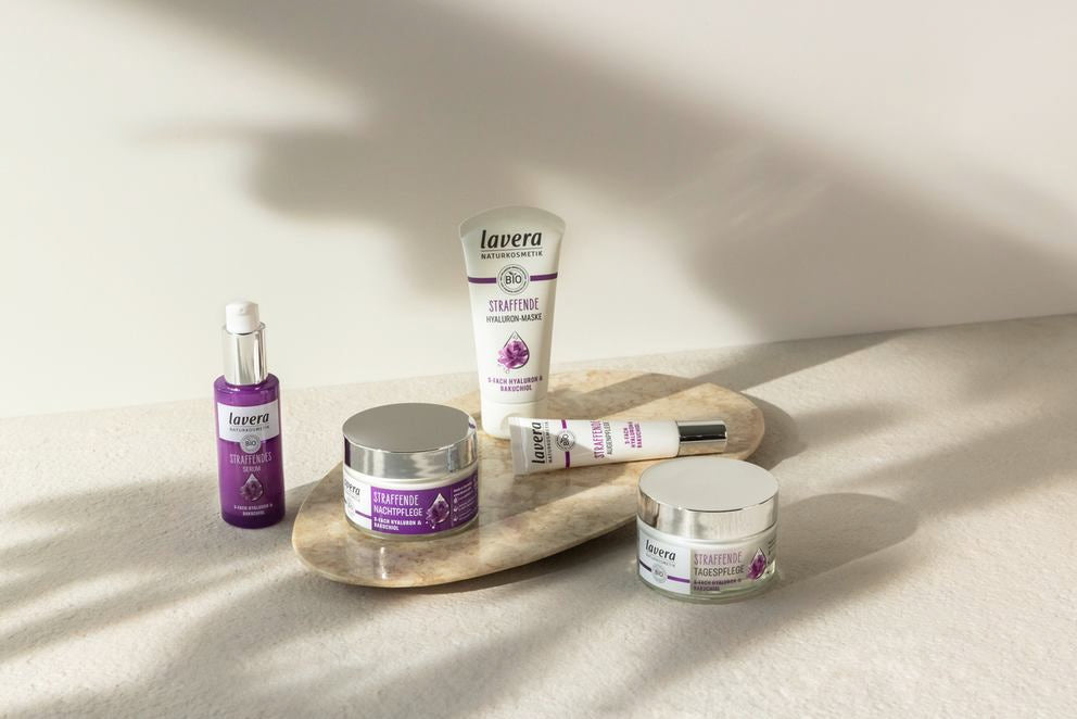 lavera ujędrniająca seria pielęgnacyjna z pięcioma fioletowymi produktami na kamieniu