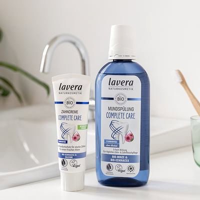 lavera Complete Care pasta do zębów i płyn do płukania ust przy umywalce