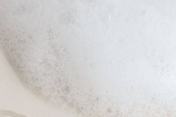 Delikatna piana oczyszczająca w zbliżeniu z lekkimi bąbelkami