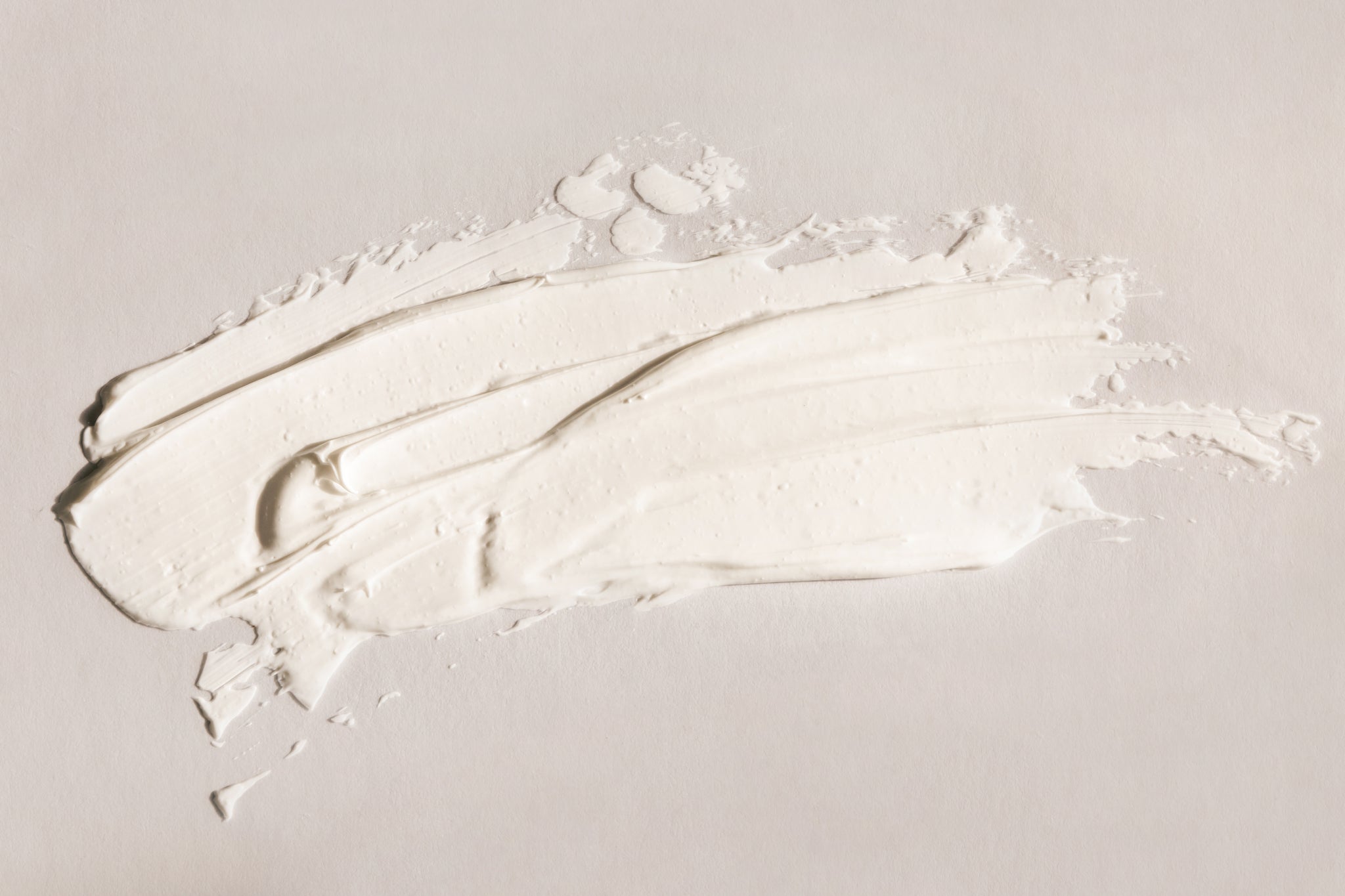 Creme-Textur auf beigem Hintergrund ausgebreitet