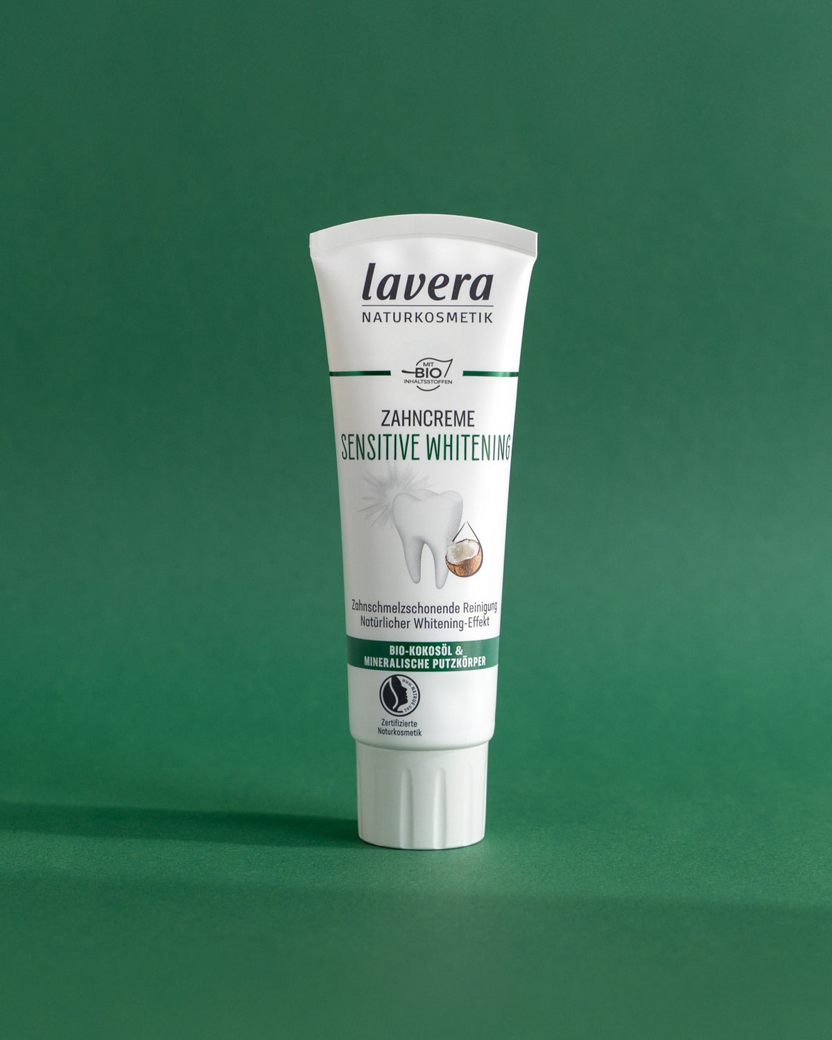 Pasta do zębów lavera Sensitive Whitening na zielonym tle