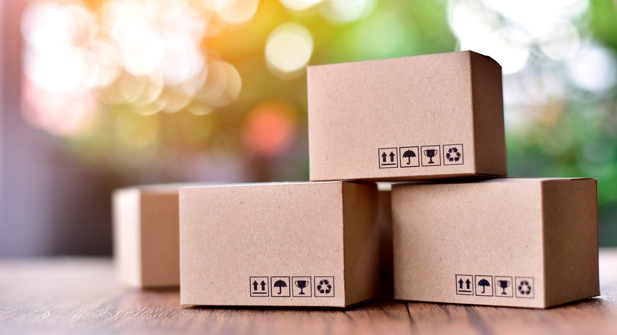 Stos kartonów z symbolami wysyłki na drewnianym stole, wysyłka paczek